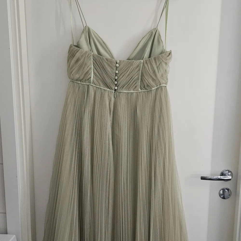 Salviagrön klänning i mesh tyg med underkjol. Köpte på ASOS. Använd 1 gång, storlek 40. Uppsydd hos skräddare för att passa ca 1.69 lång person ner till marken. Nypris: 1109:-. Klänningar.