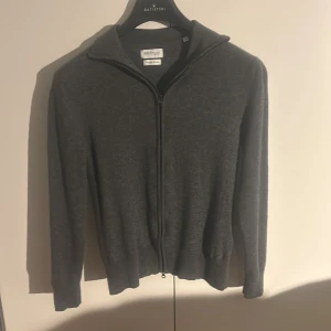 These Glory Days cardigan  - Säljer nu min riktigt snygga och trendiga These Glory Days cardigan i snygg grå färg. Tröjan är i merinoull och i bra skick. Säljer den pågrund av att den är för liten. Är i storlek M men är väldigt lite i storlek så passar S.