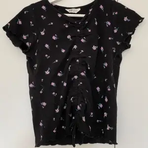 En svart t-shirt med små blommor på från H&M
