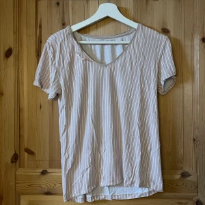Randig T-shirt  - Fin randig T-shirt från lager 157. Två små hål i ryggen men det är inget som märks