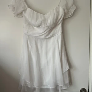 Vit kortklännig - Jättefin vit kortklänning, från Nelly. Kan både bäras off shoulder och on shoulder. Storlek 38, säljer för 100kr. Köparen står för frakten.