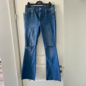 Blå bootcut jeans från H&M med hål i knäna. Storlek 40, bra skick.