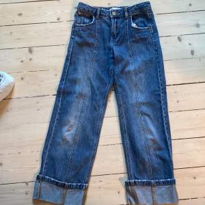 Jeans med uppvik. 52 cm långa.