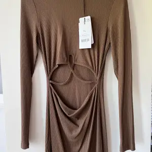 Säljer denna bruna klänning från NAKD i storlek XS med prislapp kvar💕💕öppen på magen 