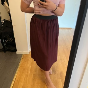 Vinröd midikjol  - En väldigt fin midikjol som är normal i storleken och otroligt skön