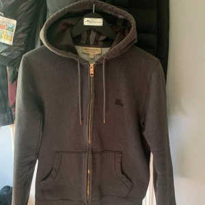 Burberry Zip Hoodie - Säljer min Burberry Zip Hoodie i färgen Dark Grey (sällsynt färg) storlek S då den ej passar mig längre. Autentisk✅ Fler bilder/info finns i DM. Priset ej hugget i sten.