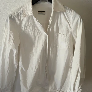 Malene Birger vit skjorta  - Vit poplin skjorta från malene birger. Superfin men har två små fläckar på sig ( se bild) men går säkert bort med vanish eller så! 