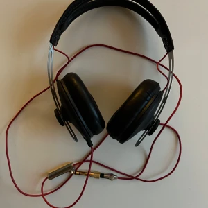 Sennheiser Momentum hörlurar - Säljer hörlurar från Sennheiser, modell momentum. Svarta med röda detaljer. Ljudadapter från 3,5 mm till 6,3 mm medföljer. I mycket god skick. Fullt fungerande .