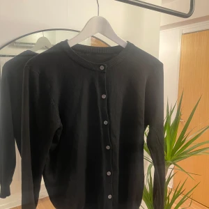 Svart kofta med knappar  - Svart kofta med knappar i storlek L. Passar även M. 