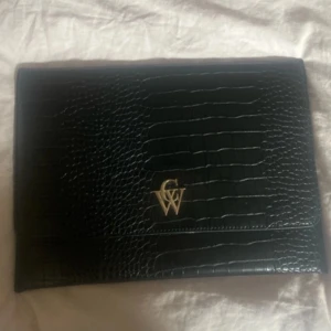 Datorfodral - Från Carin Wester. Bra skick. Enda märkbara defekt är på det guldiga märket. Kolla bilder noga för skicket. Jättefin 🥰 måtten är: 35,5 x 25 cm.