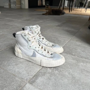 Nike x Sacai Blazer mid  - Nike x Sacai Blazer Mid som jag har haft i runt 4 år. Sulan är sliten och har börjat lossna lite, se bild 5. Har tyvärr ingen box och har tagit ut ett par snören och vet dessvärre inte var dem är.