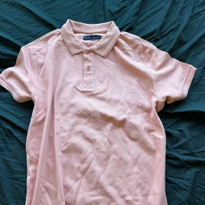 Snygg pikétröja  - Pikétröja från märket som står på lappen. Färgen är rosa/aprikos, lite svårt att ge rättvisa på bild. Väldigt bra skick då den knappt är använd! 💕strl M 60kr och köparen står för frakt.