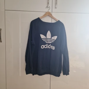 Bekväm adidas tröja - Adidas tröja i XL men funkar som XXL också. 70% bomull 30% polyester. Sprickor på loggan men inget som flaggnat. 