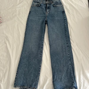jeans vero moda - högmidjade blåa utsvängda jeans som aldrig är använda ! W30 L32, endast tajta över höfterna/rumpan annars utsvängda ! slitningarna på fickorna och sömmen där nere på byxbenen ska vara där, var så när jag köpte :) mått står på bilden, inte stretchiga