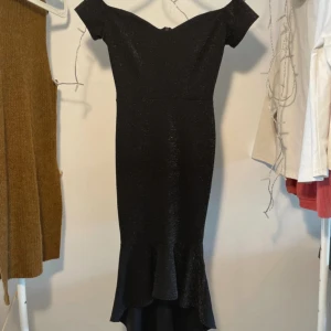 Glittrig klänning - Off shoulder och asymmetrisk kjol. Stretchigt tyg, fint skick!