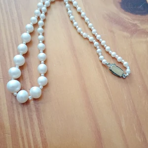 Pärlcollier med vita pärlor stora och små.låsbart. - Gammalt pärlcollier med stora och små vit gula pärlor låsbart.