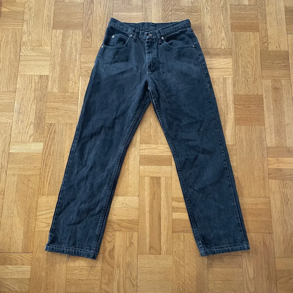Svarta stentvättade Wrangler Jeans! I bra skick men har lite defekter, kan skicka bild vid intresse! Uppskattar till storlek ell större 36/38?. Jeans & Byxor.
