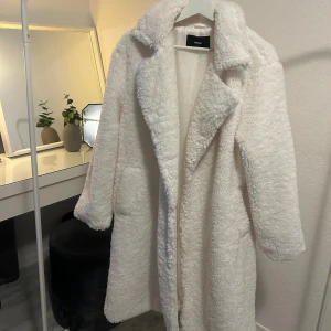 Vit lång kappa  - Vit lång ”teddy” kappa från BikBok 🤍❄️ Aldrig använd! Köpt för 899kr, men säljer för 600kr. 
