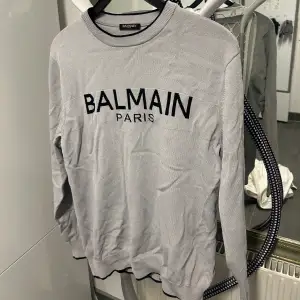 En grå Balmain Paris tröja i storlek Medium. Köpt i Dubai mall för ca 2 år sedan. Använd ungefär 6 gånger. Skrynklig från att ha legat i garderoben, annars är skicket 9/10!  Köpt för ca 4500kr