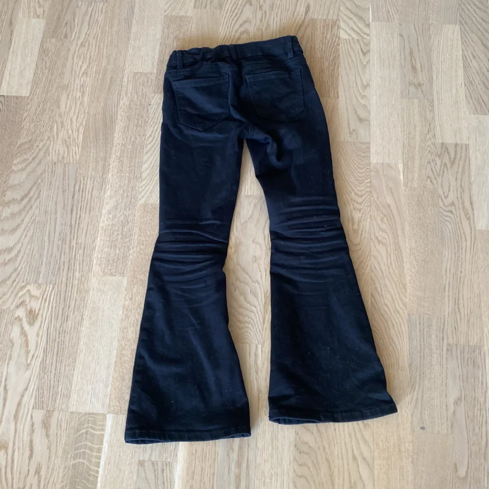 Svarta lågmidjade bootcut jeans i barn size . Jeans & Byxor.