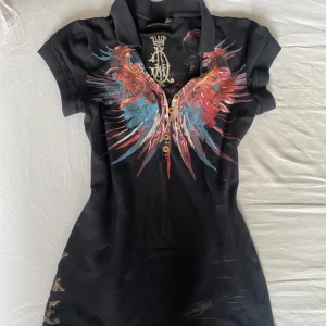 Christian audigier pike - Säljer denna jättefina Christian audigier polo/pike tröjan med rhinestone på ryggen💞jättefin, lite ed Hardy vibes. Köpt på plick för ett tag sen men har inte använt så mycket då den är lite stor för mig, tryck gärna på köp nu!