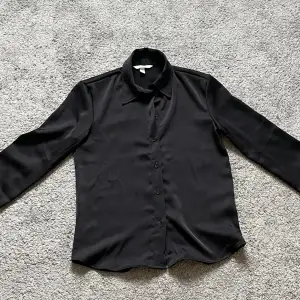 En svart silkes skjorta som användts 1 gång
