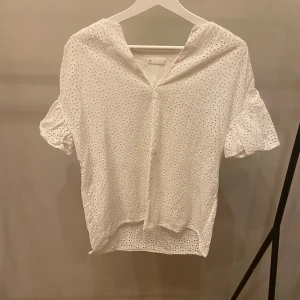 Blus från arket - Somrig blus från arket med ett fint hålmönster i storlek 38 | Skick 6/10 pågrund av två små fläckar men som knappast syns. Skriv gärna om ni har några frågor eller funderingar!