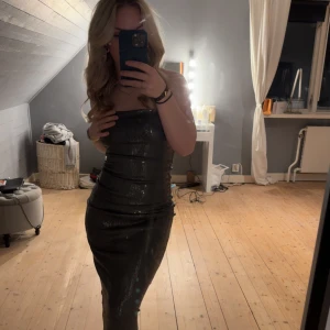 Cocktailklänning - Säljer denna fina cocktailklänningen i mörk grå , bara använd en gång så är helt som ny 