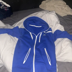 Lacoste zip hoodie  - Hej säljer min Lacoste zip pågrund av att den är lite liten knappt använd. Den är väldigt bra skick. Strl XS-S