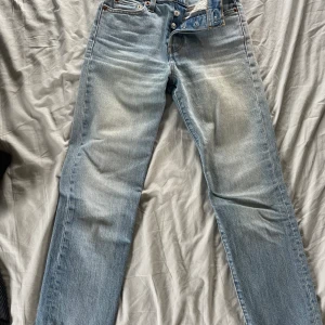 Högmidjade raka Levis jeans - Ett par fina ljusblåa byxor från Levis och fint skick! Står stl W24 och ungefär 33cm i midjan och klippta till 64cm innerbenslängd.