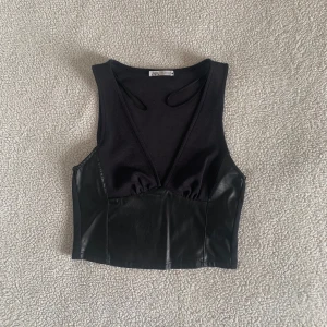ZARA svart PU skinn-topp - Snygg topp med PU-skinn i stretchig passform. Använd en gång, utan anmärkningar.