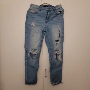 Jeans med slitning - Stiliga byxor med slitning på framsidan enligt bild.