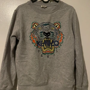 Kenzo tröja - Kenzo tröja i bra skick. En liten fläck bak på ryggen men inget man tänker på. Annars är det inga skador på den. Passar 164