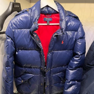 Ralph lauren dunjacka - Säljer denna Ralph lauren vinterjacka. Jackan har inga defekter som hål osv. Alla knappar sitter som de ska. Storlek 14-16 years, skulle passa nån som är 165 +/- minus ett par cm!