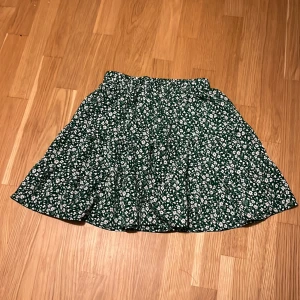 Grön blommig kjol - Såå fin kjol till sommaren! Resor i midjan. Lite nopprig på visa ställen därför sänks priset rätt mycket. Använd ett fåtal gånger. 🫶