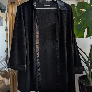 Glittrig skjorta/blus  - Vintage skjorta med invävd glittertråd, lite genomskinligt, superfint tyg! Köpt på Vino Kilo. Står inte vad det är för storlek men tyget är stretchigt så passar allt mellan S-L.