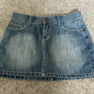 vintage 2000’s jeanskjol - Jättesnygg vintage 2000’s jeanskjol. Den är aldrig använd och i superbra skick. Den har en blomdesign på fickorna och är  ljusblå. Storlek M men sitter super bra på mig som har runt storlek 36. Rökfritt hem. Frakt betalas av köparen.