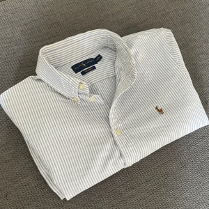 Ralph lauren skjorta - En snygg randig Ralph lauren skjorta i storlek M, skulle säga att den passar lite mindre. Bra skick, minimala tecken på användning men inget som syns. Kom privat för fler bilder eller vid frågor!