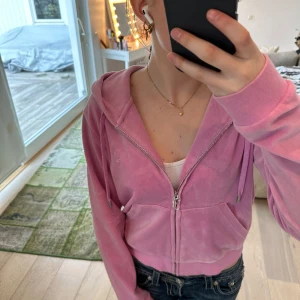 Rosa Juicy Couture Sip-up Hoddie  - Säljer denna rosa Juicy Couture tröjan i storlek M. Säljer för att den inte kommer till användning längre. Använt flitigt men stans ej då den är i fint skick. Är 168 och är någon cm för lång i armarna annars passar den perfekt. Ny pris 1300 kr. 