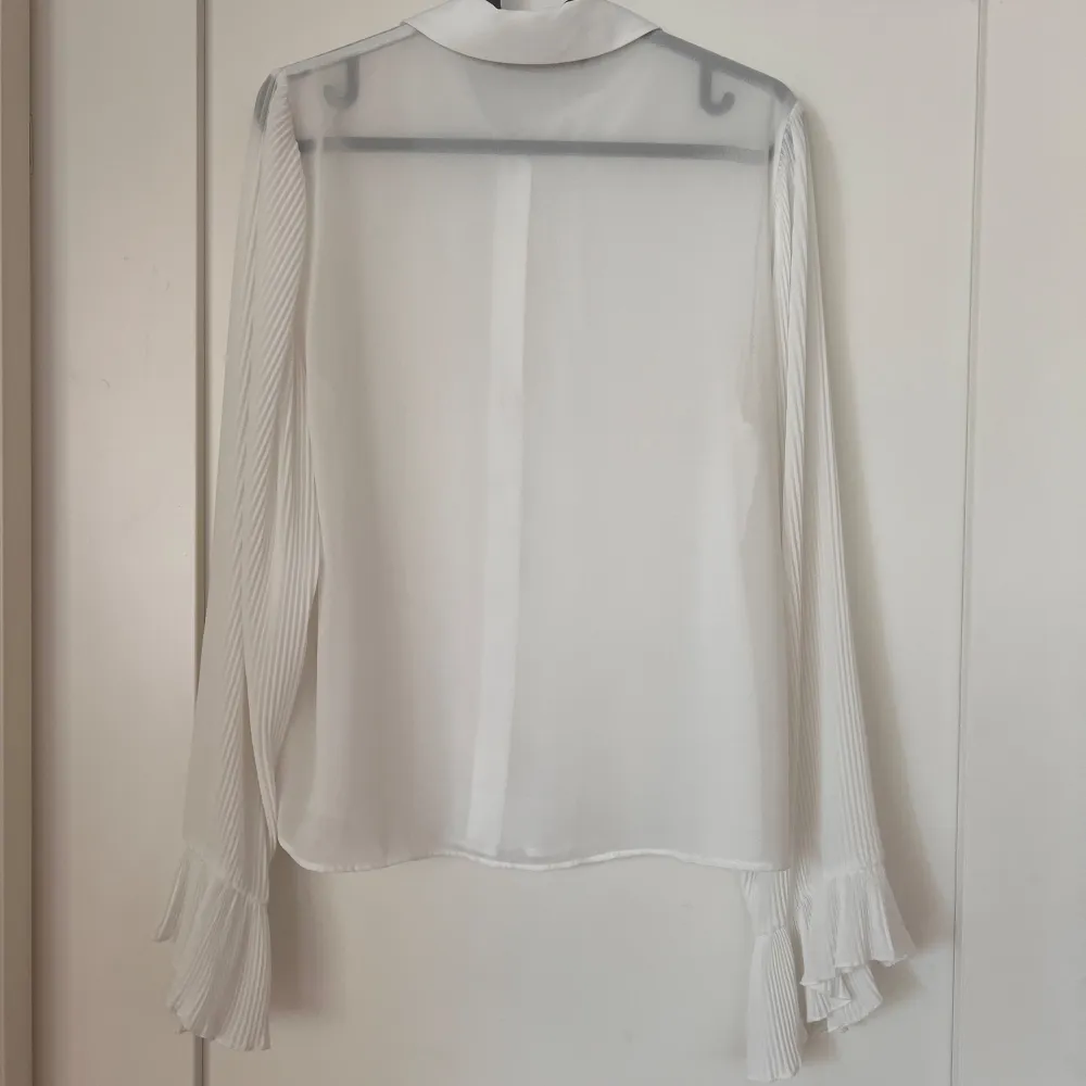 Lätt transparent vit blus från ZARA. Plisserade armar med volang.  Strl. M (passar en S-M). Blusar.