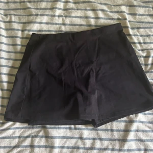 Svart träningskort - Oanvänd svart skort. Kort i längden, minikjol. Har en ficka på högra benet. 