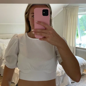 Blus med rosett i ryggen - Kort Vit topp med rosett i ryggen, aldrig använd 💕