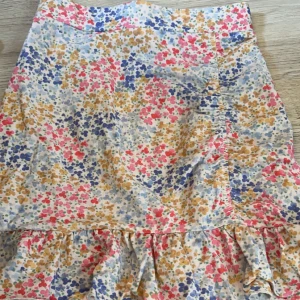 Kjol  - Söt liten kjol med multifärgade blommor.