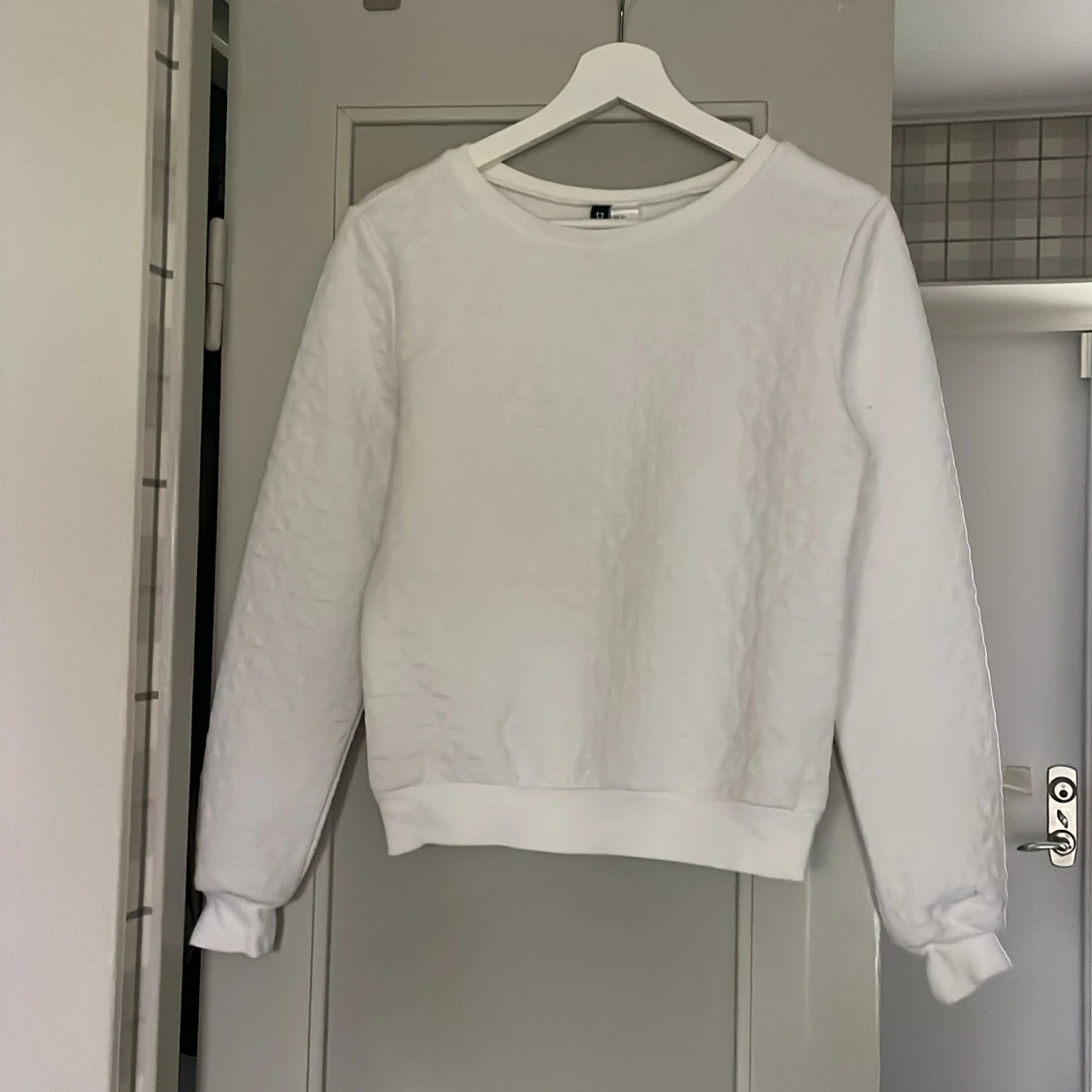 Vit collegetröja med detaljer