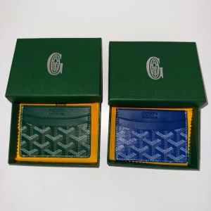Märkes Plånböcker - Säljer två stilrena märkes plånböcker i grönt och blått. Den kommer i originalförpackning. 1 för 200kr och 2 för 400kr. 