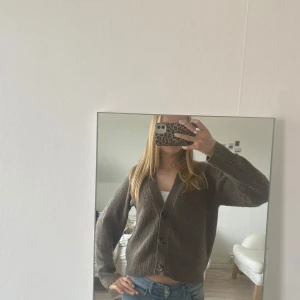 Brun kofta med knappar - Säljer en mysig brun kofta med knappar framtill. Perfekt för kyligare dagar och lätt att matcha med olika outfits. Koftan har långa ärmar och en klassisk design.