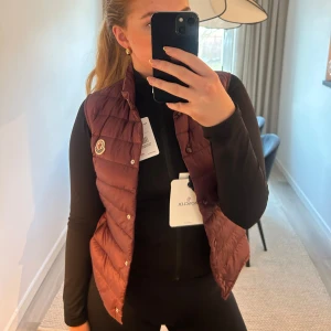 Väst Moncler - Snygg dunväst från Moncler med knappar och klassisk design. Otroligt snygg färg och är helt i nyskick. Köpte den från Vestiaire men köpte i för liten storlek och glömde skicka tillbaka. Storlek 1