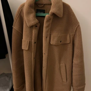 Brun teddyjacka från LCW Casual - Säljer en mysig brun teddyjacka från LCW Casual. Jackan har en oversized passform med långa ärmar och knappar framtill. 