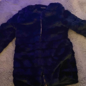 Svart pälsjacka med dragkedja - Snygg svart pälsjacka med dragkedja framtill. Jackan har en mjuk och fluffig yta som ger en lyxig känsla. Perfekt för kyliga dagar när du vill hålla dig varm och stilren. storlek M passar S