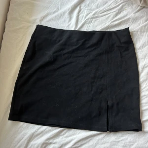 Svart kortkjol - Snygg svart kortkjol med en liten slits framtill. 